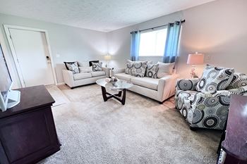 A living room with a white couch and a patterned armchair.